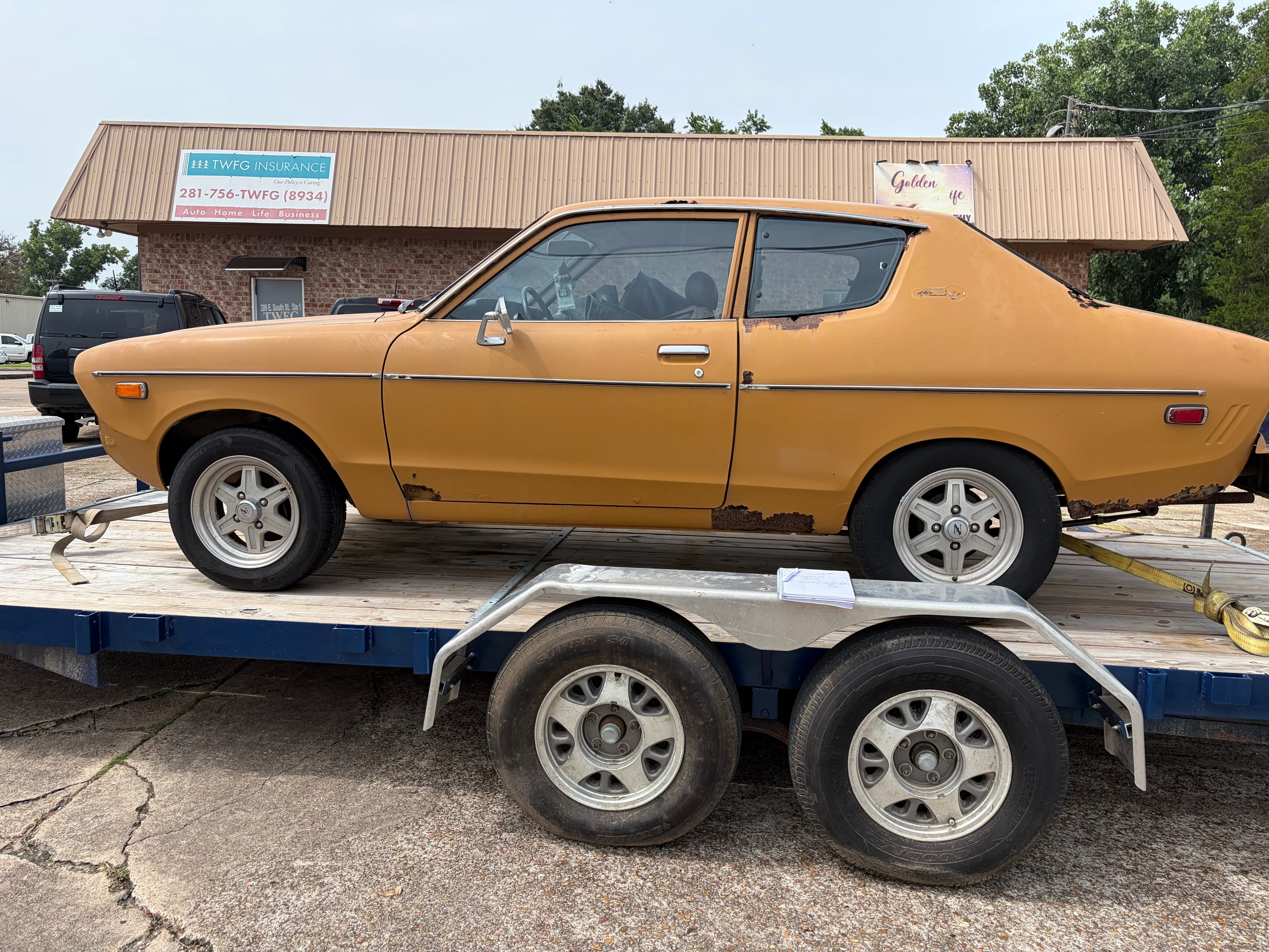 Gold Datsun on transport trailer — classic car appraisal